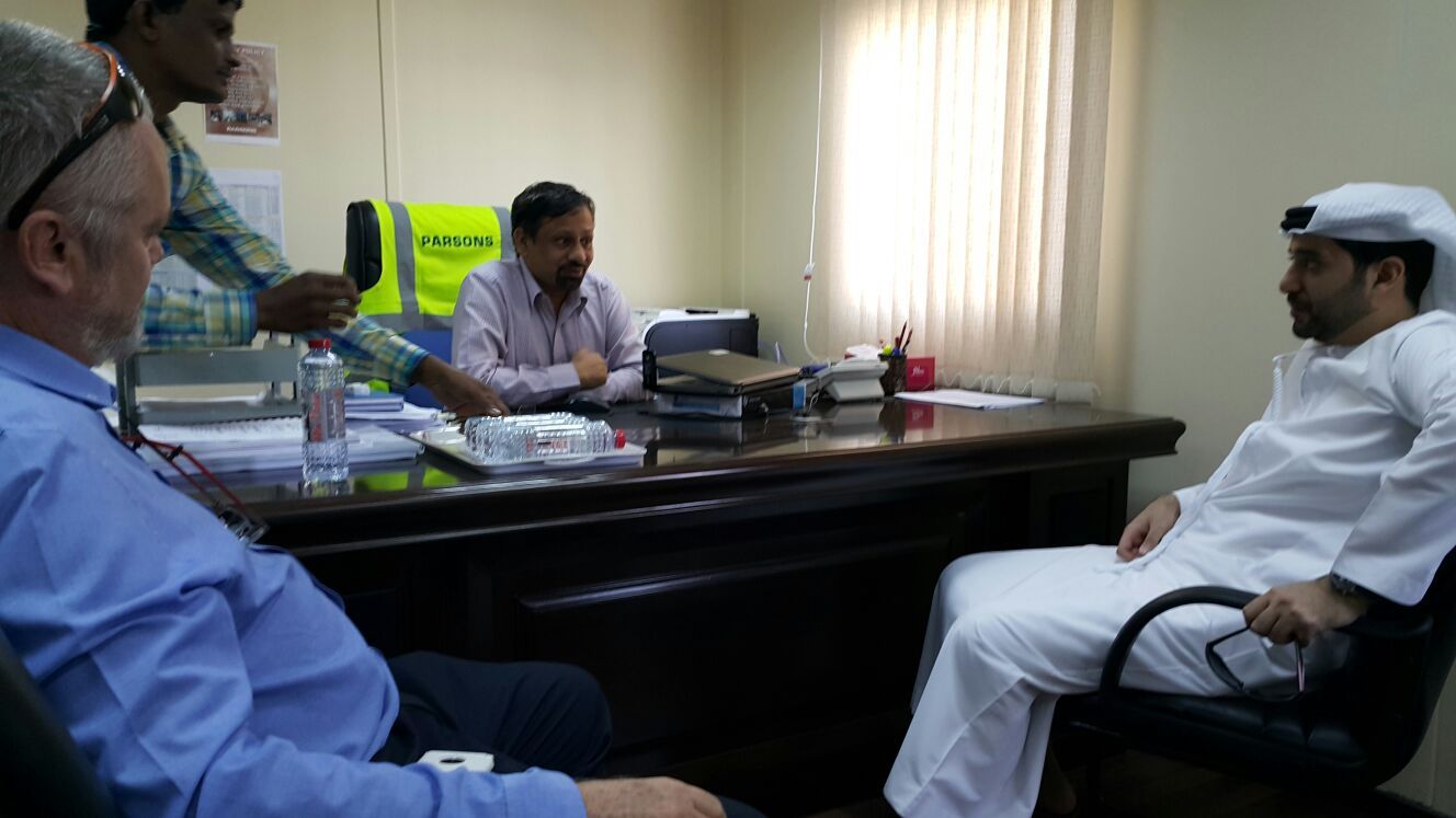 Project office meeting between the supervision team and a senior visitor in Emirati dress