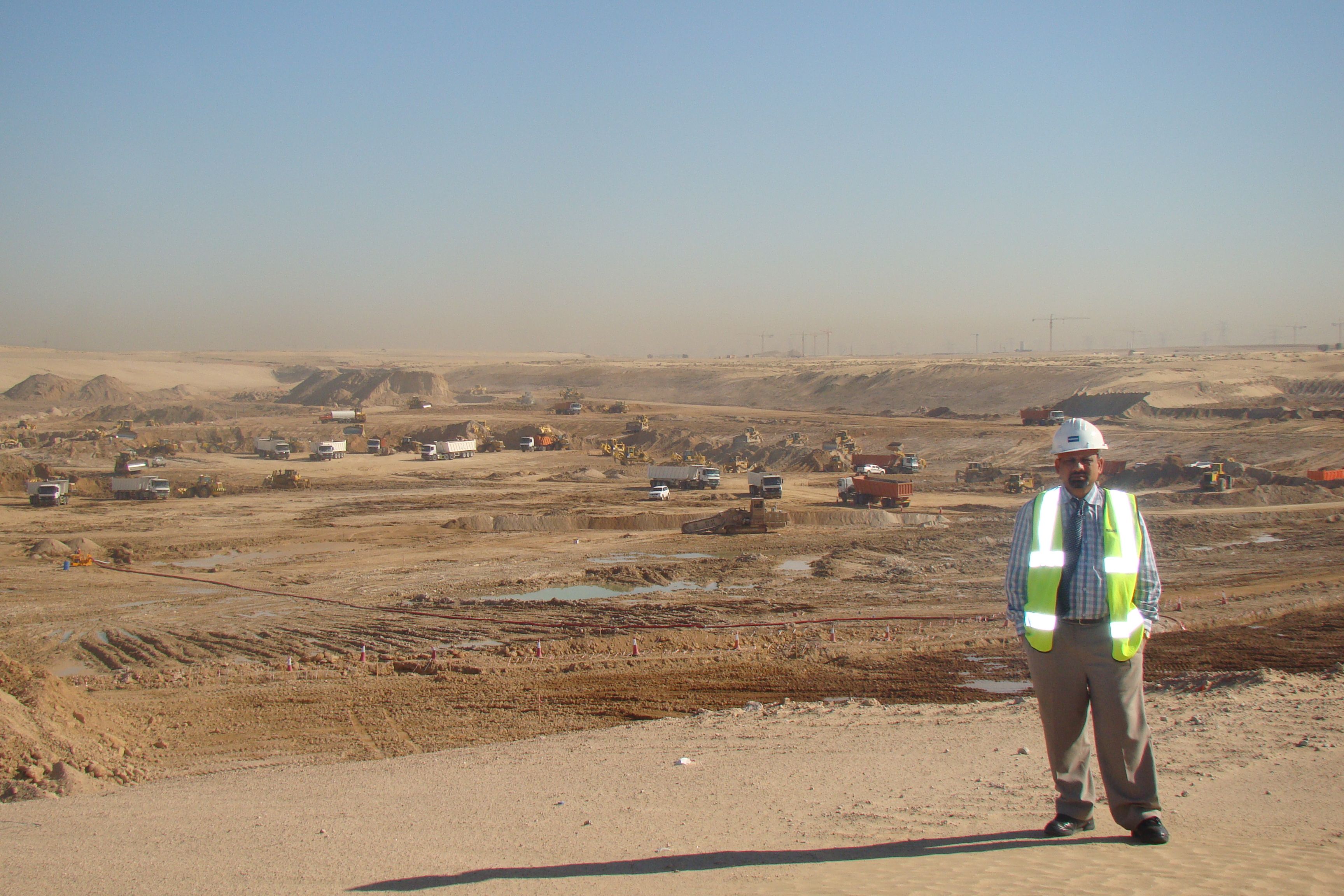 Basavaraj Hiremath on the edge of the Arabian Canal excavation, plant working across the cut to the horizon