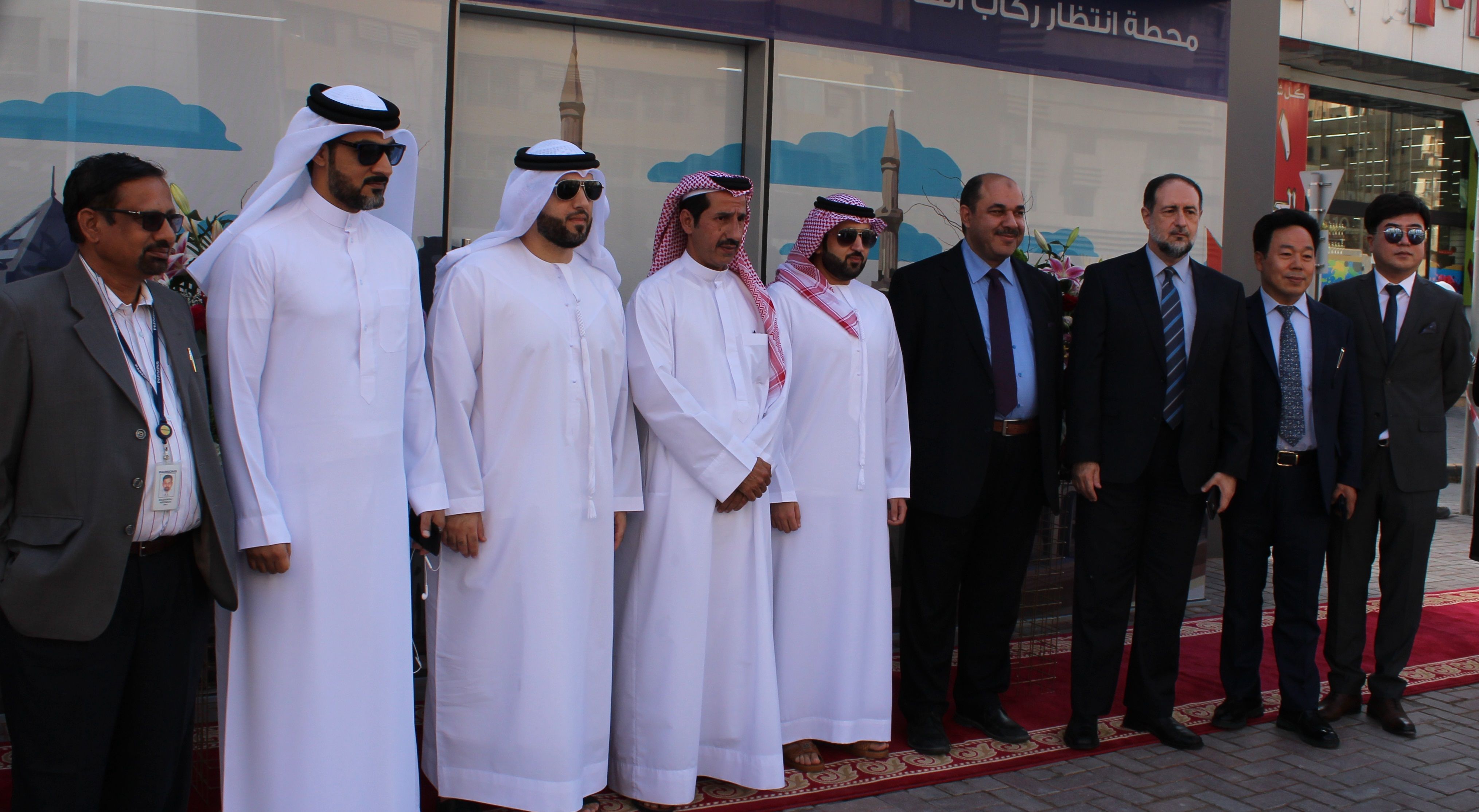 Handover ceremony, officials assembled outside a completed facility