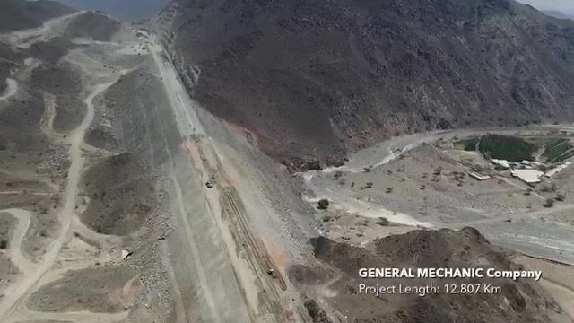 Aerial view of the Wadi Helou alignment under construction, the cut carriageway running along a mountainside above a wadi